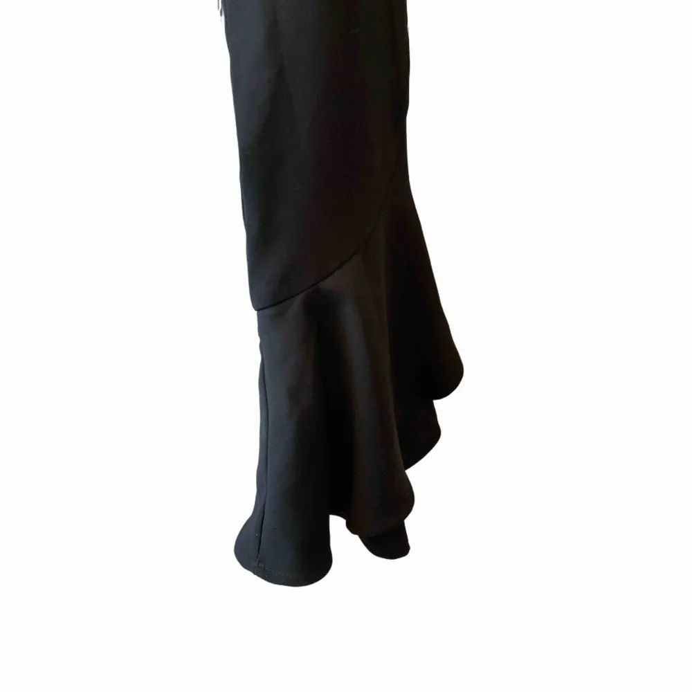 Ett par svarta kostymbyxor med volanger längs ner på benen! Supersnygga att ha för att lyfta en outfit och sitter väldigt smickrande på kroppen. Storlek XS👊🏻✨. Jeans & Byxor.