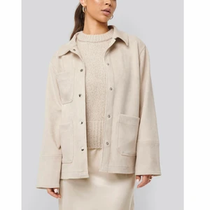 NA-KD skjortjacka - (Första bilden lånad) Beige skjortjacka från NA-KD med lite oversized passform. Använd 1-2 ggr. Köptes för 599:-. Köparen står för frakten. 