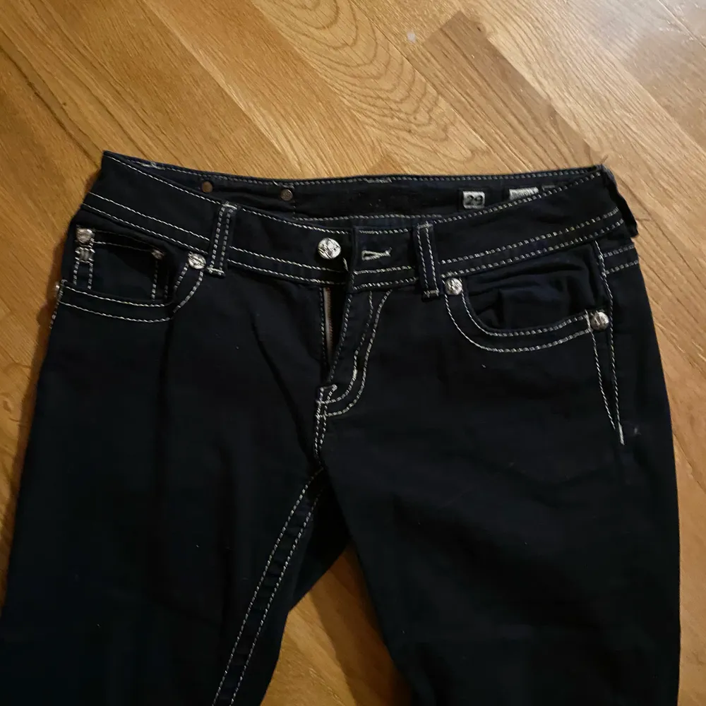 Svarta as coola jeans med vita sömmar. Fickor med änglavingar på. Använda ca 3 gånger. Low waisted! Storlek 28. Jeans & Byxor.