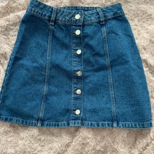 Snygg blå jeanskjol - Säljer denna fina blåa jeanskjol från H&M med knappar framtill då den är för liten för mig och inte änvänds. Kjolen är i jättefint skick! Budgivning vid flera köpare!🥰