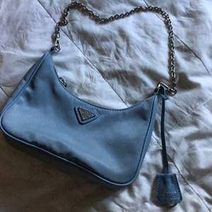 Säljer min fina ljusblå Prada väska (fake). Köpt utomlands och ser ut som äkta. Jättebra skick. Köpt för 500. (Man får med det andra bandet också)