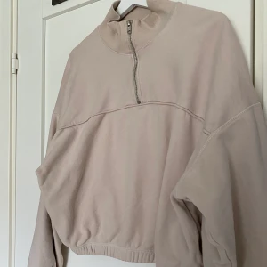 Tröja med krage  - Säljer denna mysiga tröja från weekday i en beige/ljusrosa färg. Snygg med dragkedjan som går upp i halsen och muddarna i ärmarna och längst ner på tröjan🧡 köparen står för frakten! Skulle säga den sitter som en S-M