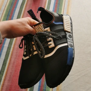 Adidas NMD_R1(core black / collegiate royal / active red) storlek 44 2/3.  - Adidas NMD_R1 i nyskick, köpta på footlocker i Prag. Använda fåtal gånger och minimalt slitage. Var för mig ett onödigt och inte ett speciellt genomtänkt köp och de har helt enkelt inte använts. Ordinarie pris 1499kr