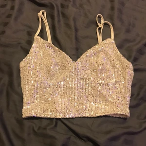 Glittrig topp - Säljer denna fina fest topp i ny skick.