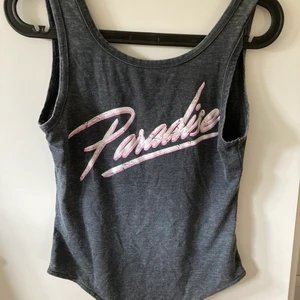 bikbok - En grå body från Bikbok där det står ”Paradise” på i storlek S