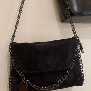 Stella mccartney liknande väska - Säljer min stella McCartney liknande väska då jag råkade köpa fel modell. Köpt för ca en månad sen och använt endast ett par gånger. Nästan helt nyskick och absolut inga fel med väskan. Svart med glitter, leopard mönster inuti väskan med silver kedjor. Väldigt fin och nästan helt ny. Kan antingen mötas eller frakta 