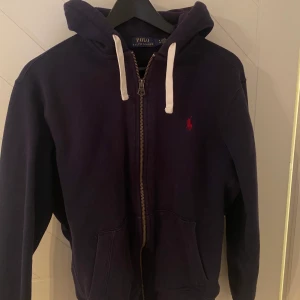 Mörkblå Ralph Lauren hoodie  - En mörkblå Ralph Lauren hoodie i fint skick. Inköpt i Amerika för nypriset 1200:-. Storlek medium.