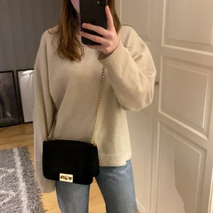 Sammetväska från GinaTricot - Inprincip helt ny väska från GinaTricot. Väskan har inte kommit till någon användning. Svart väska med guldiga detaljer som kedja och knapp. 80 kr + frakt.