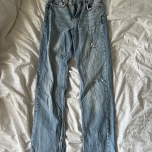 Gina Jeans - Raka jeans med slits nedtill och lite slitningar. Är i petite modell så passar mig som är ca 160 lång. Stl 32, knappt använda. Kan skickas mot betalning av fraktkostnad 