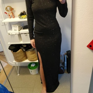 Nly eve långklänning   - Svart glittrig långklänning från nly eve storlek 38. Mycket bra skick! Slits framtill och öppen rygg, superbekvämt stretchigt material. Perfekt till jul eller nyår! 