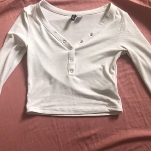 Ribban top med knappar  - Ribbad och kroppad top med knappar. Jag är storlek xs/s och den är inte jätte kort på mig. Toppen är i xs men man kan ha den om man är medium (töjbart material.) PS köpare står för frakt