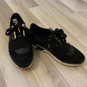 Sneakers - Unika sneakers med gulddetaljer från River Island i nyskick. Enbart använda vid enstaka tillfälle, Mycket bekväma att gå i. Säljer pga att de inte riktigt är min stil. 