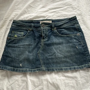 Lågmidjad jeanskjol - Blå lågmidjad jeanskjol med neongröna sömmar från bershka, storlek 36. Kan mötas upp på Lidingö eller i centrala Stockholm 