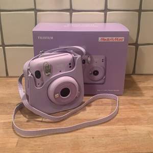 Säljar denna en lila Polaroid kamera som jag råkade köpa två av. Fick i december så den är ny och helt oöppnad! En kamera väska medföljer, bilder köps själv. 