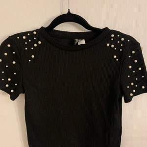 Svart t-shirt - Svart kort t-shirt med pärlor 