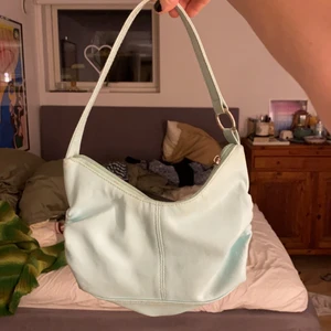 Blå handväska  - Säljer denna supersöta blå väskan med silver detaljer. Den har ett stort fack och ett litet med dragkedja inuti så man får plats med en del. Köpt secondhand men inte så sliten❤️skriv vid frågor❤️💋