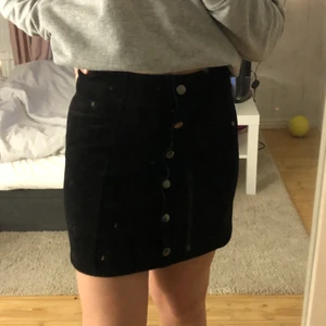 Svart kjol med knappar - Svart ribbad kjol med fejkknappar. Den är från Ginatricot, stretchiga och i storlek S💗