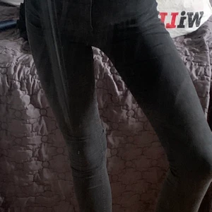 Svarta Molly jeans storlek S - Superstretchiga highwaist jeans med en figurnära passform från ginatricot. Jeansen är svarta och har en hög midja. De har fickor på baksidan och fuskfickor framtill. Storlek S. Byxorna är gjord av 98% bomull och 2% elastan. Skontvätt: 30 grader. Byxorna är tvättade ofta så därför har lite färg försvunnit men det är inget man märker när man har dem på, också olika alla ljus. Annars är den i gott skick, inga håll osv. 