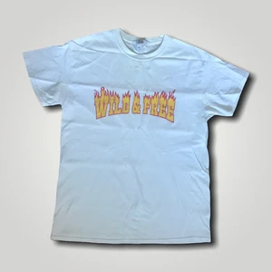 WILD & FREE - Köpt från NELLY. En enkel vit t-shirt med tryck på, härligt material. Condition: 8/10. Frakt är 45 kr. Köp nu! 😊