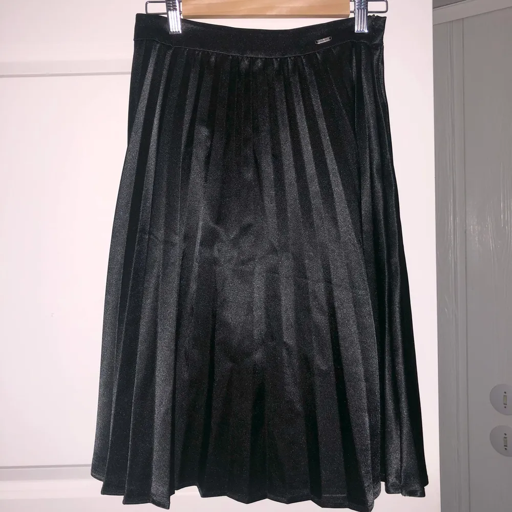 Supersnygg svart plisserad midikjol i satin från Guess! 🖤 Går precis över knäna på mig som är 168 cm lång. Pris: 200 kr + frakt. Kjolar.