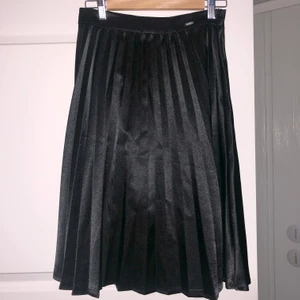 Plisserad kjol - Supersnygg svart plisserad midikjol i satin från Guess! 🖤 Går precis över knäna på mig som är 168 cm lång. Pris: 200 kr + frakt