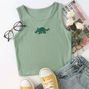 Grön crop top - Grön crop top med en broderad dinosaurie på som tyvärr var för liten i armhålorna. Nypris 109 kr från shein och det är en storlek medium men är liten i storleken så passar nog mer en small💞