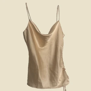 Satin cowl neck top  - 🌟 Nedsatt pris, doneras snart!🌟 Champagne färgad satin topp med dragsko detalj på sidan. 🪞från ”petit” linjen och skulle säga den passar 34/36. 🪞5/5 skick med lapp kvar 