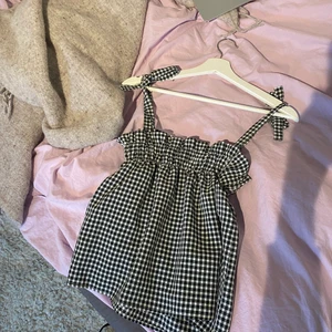 Rutigt linne med rosetter🤍 - Jättegulligt linne med knytning på axelbanden! Använd 1-2 gånger så i mycket bra skick!