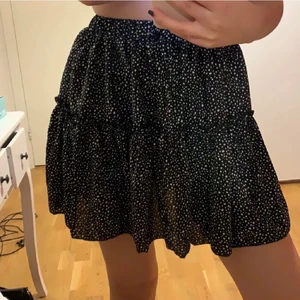 Volangkjol med prickar - Superfin svart kjol med vita prickar. Aldrig använd. Jag är 165 cm lång och frakt tillkommer 💕