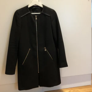 Zara kappa strl xs - Svart kappa från Zara i storlek XS. Jag skulle säga att den fungerar på en S/XS. Använt skick samt med en dragkedja som saknar ”handtag”. Väldigt älskad och använd kappa som har några användningar kvar i sig💓