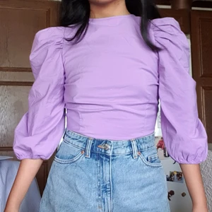 Lila blus - Lila blus med puffiga armar! Kommer inte till användning så säljer endast använd 1 gång och kostade 400 när ja köpte förra året. Passar xs-s då man kan justera storleken med banden bakom. Dock inte bra för någon med större byst då den har lite stretch
