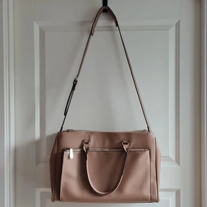 Beige bag with laptop compartment - Beige bag with five compartments. One padded compartment for a laptop. Removable strap. 40x27x15 cm. It has defects on both handles (on the picture), otherwise in good condition. Inside it has a pocket with a zipper and a pocket for your phone.