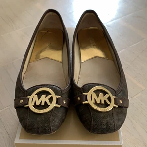 Michael Kors ballerina Fulton moc  - Ett par Michael Kors ballerina Fulton moc i strl 7,5 (38) inköpta på Jackie för 1200kr. Gott skick, lite slitna under baktill/häl (se bild). 300kr eller bud.