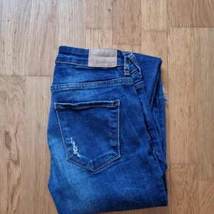 Jeans med slitningar - Låga jeans med slitningar från ginatricot, storlek 27/32 