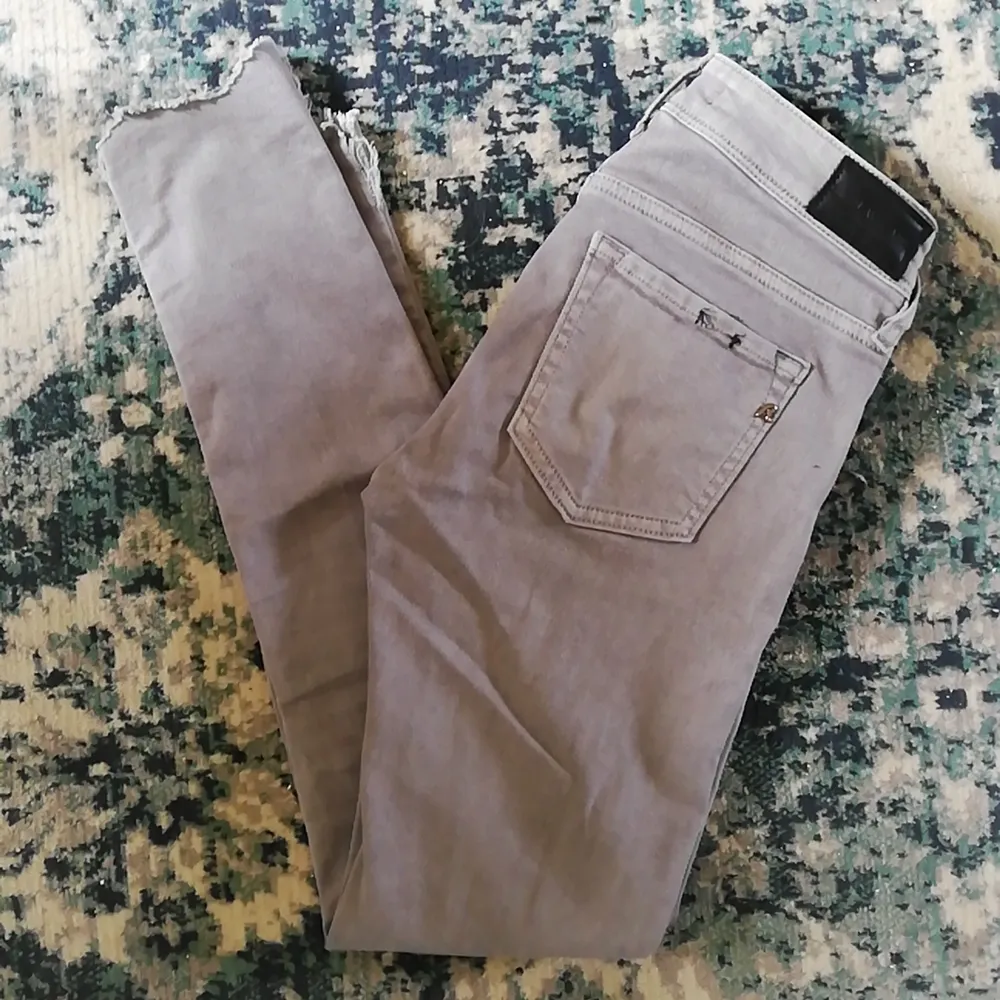 Super tajta gråa strechjeans från märket Replay med snygga detaljer och avklippt rå kant längst ner, helt nya. . Jeans & Byxor.