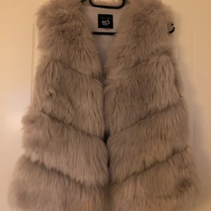 Päls Väst - En ljusgrå pälsväst, en kortare modell säljer billigt då den inte kommer till användning