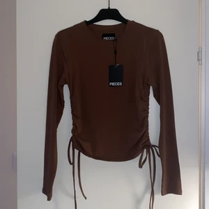 Snygg långärmad tröja - Skit snygg långärmad tröja i färgen brun storlek S man kan dra åt banden hur mycket som helst och den är aldrig använd lappen sitter kvar i och den sitter otroligt fin men är tyvärr en storlek för liten på mig nypris:279 mitt pris:139