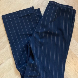 Randiga kostymbyxor  - Svarta randiga kostymbyxor. Sitter högmidjat och raka vid benen. Försmå för mig som är 38/M men skulle passa perfekt för en 36/small.