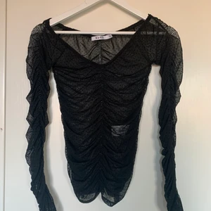 Svart topp - Jättefin svart mesh topp med prickar på, den är ifrån na-kd storlek xs❣️ jag kan mötas upp eller frakta men då betalar köparen för frakten🥰