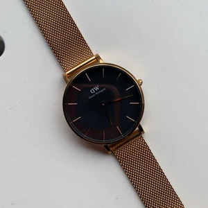 Daniel wellington rosé/svart - Klocka från Daniel wellington, 28 mm. Endast använd 1-2 ggr då färgen inte riktigt passade mig, inga tecken på användning eller repor. Nypris 1299:-