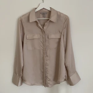 Skjorta - En beige silkeskjorta i strl 40 men passar mer S/M. Jättefin skjorta som verkligen passar till många tillfällen!!! Den är ljusare än vad som ses på bilderna🥰 