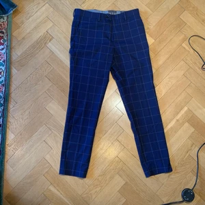 H&M kostym byxor - Ett par mörkblå H&M byxor i fint skick med rutigt mönster!