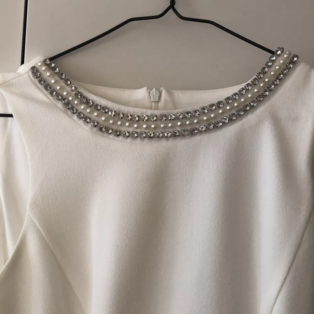 En super fin vit klänning som är helt oanvänd! Klänningen har en snedskuren look från vänster sida som är täckt i ett annat material en själva klänningen. Inköptes Australien. Klänningar.