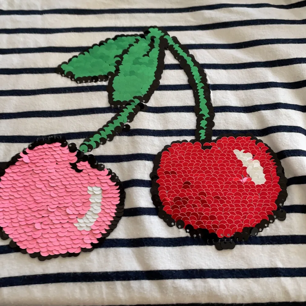 En randig tröja med en frukt  i mitten 🍇. T-shirts.