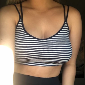 Gulligt linne - Gulligt randigt linne i marinblå och vit. Söt detalj med två band. Storlek S men passar upp till M