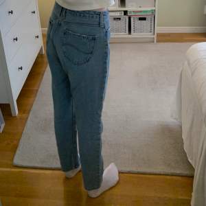 Raka mom jeans från Lee i strl. 28/31. På mig som är 175 cm slutar byxbenet vid ankeln och är midrise i midjan. Säljer p.g.a de är lite för stora på mig, men det beror helt på hur man vill att de ska sitta. Fraktkostnad tillkommer.
