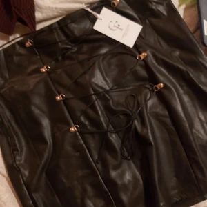 Skinnimitation kjol - Superfin kjol i matt skinnimitation, väldigt stretchig. Storlek 44, helt ny med lappen kvar. Fick fel storlek då jag beställde. Köpt för 399