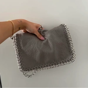 Grå Stella liknande väska  - Säljer min trendiga gråa Stella Mccartney inspirerade väska från Tiamo. Det är den mellanstora modellen, nypris 500kr. Endast använd ett fåtal gånger och i väldigt fint skick! (OBS! Lånade bilder men exakt likadan väska)💕💕💕 pris: 150kr + frakt KÖP DIREKT FÖR 270kr + Frakt!