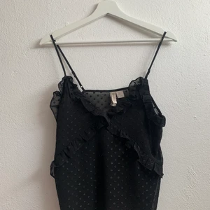 Partytopp - Säljer min svarta jättefina partytopp. Den har otroligt fina detaljer och är väldigt skön att ha på sig. Tyget i ryggen är smått genomskinligt vilket är väldigt fint.🌸🌸