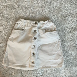 Fin vit jeanskjol  - En jättefin vit jeanskjol köpt förra sommaren. Säljer nu för att den blivit för liten. Den är i storlek 152 men motsvarar xs💗 skriv privat för mer bilder eller info💕ps! Jag vet inte vart den är ifrån men kolla sista bilder för märket. 